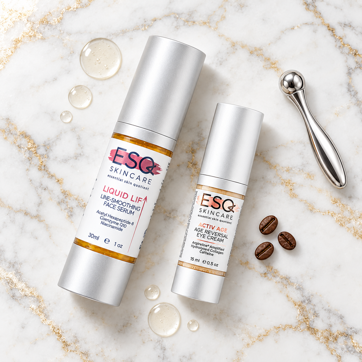 Two silver cosmetic bottles from ESC Skincare, a larger 30ml Liquid Lif Face Serum bottle and a smaller 15ml Age Reviver Eye Cream bottle, arranged on a white marble background with gold veins, alongside a silver facial roller, coffee beans, and clear serum droplets.