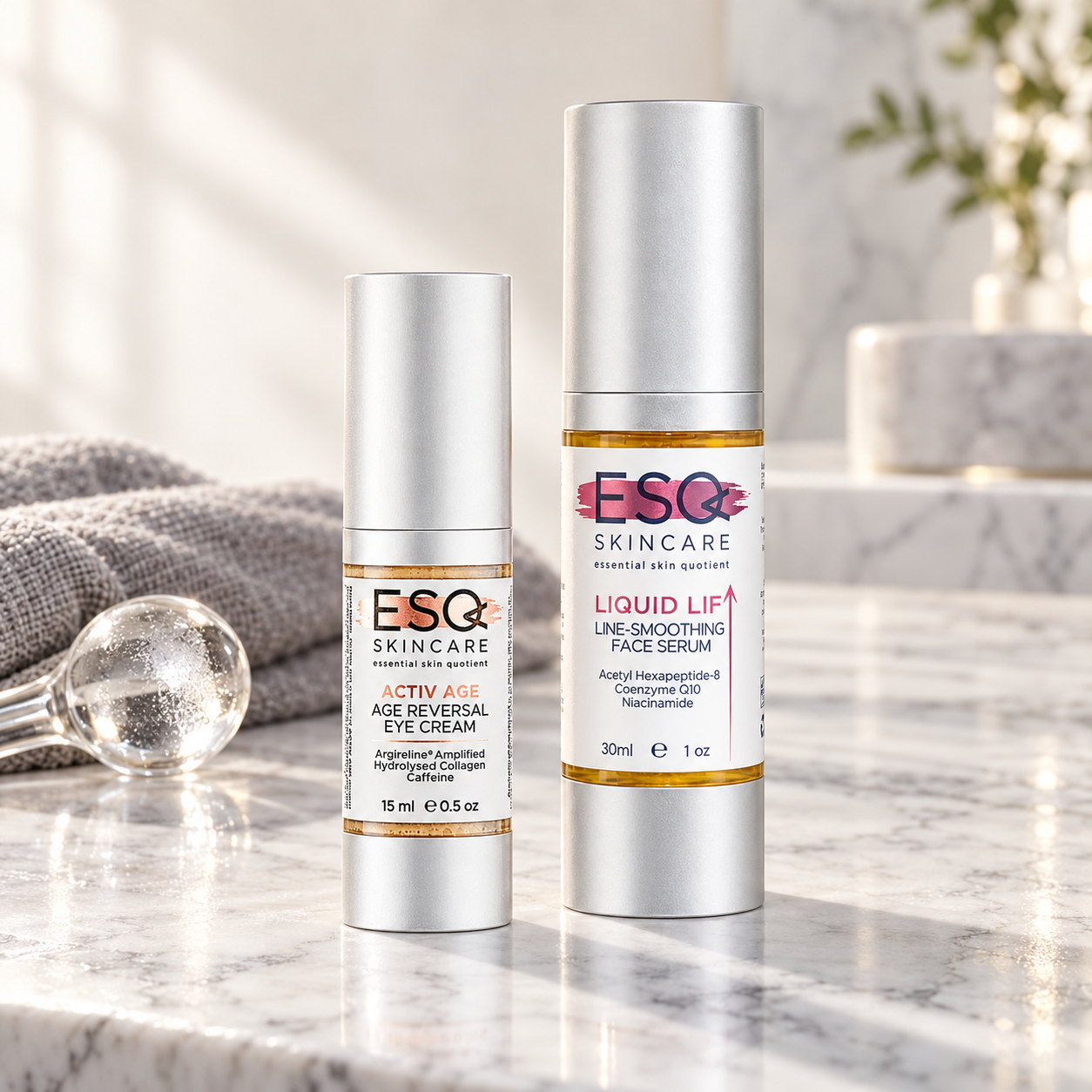 Two silver cosmetic bottles from ESQ Skincare, one Age Reversal Eye Cream and one Line-Smoothing Face Serum, displayed on a polished marble surface with a soft-focus background.