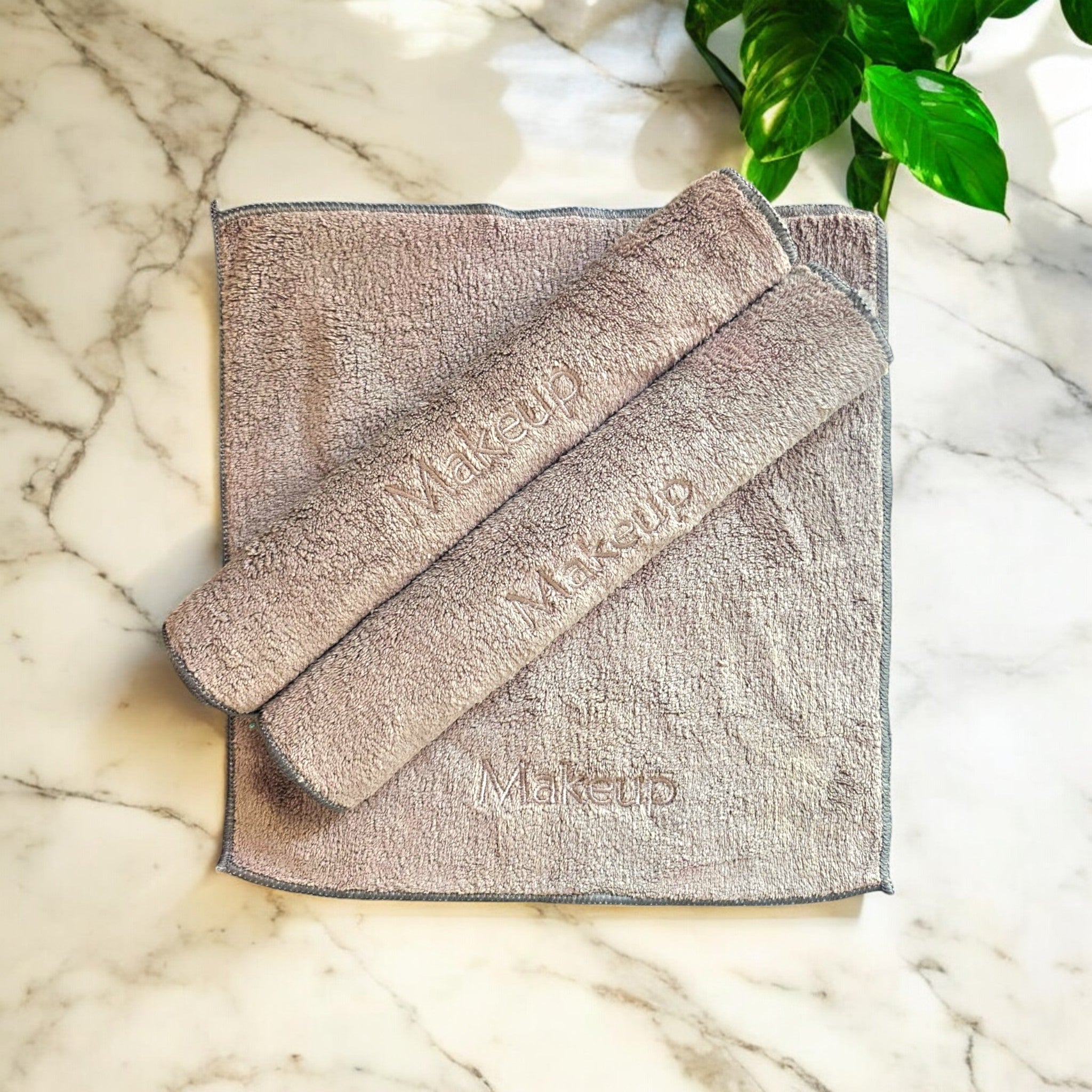 A soft, eco-friendly ESQ Skincare Clean Slate™ Microfiber Cloth in a neutral tone, neatly folded beside a skincare routine setup, highlighting its gentle, reusable, and sustainable design for effortless makeup removal. 🌿✨