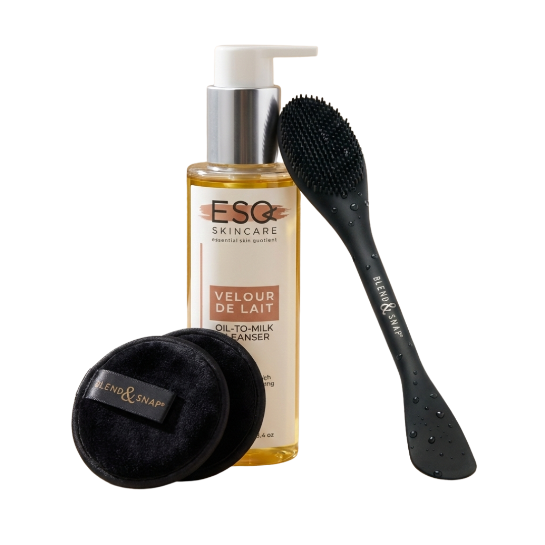 ESQ Skincare bottle with Velour de Lait oil-to-milk cleanser, a black brush, and two black pads on a white background.