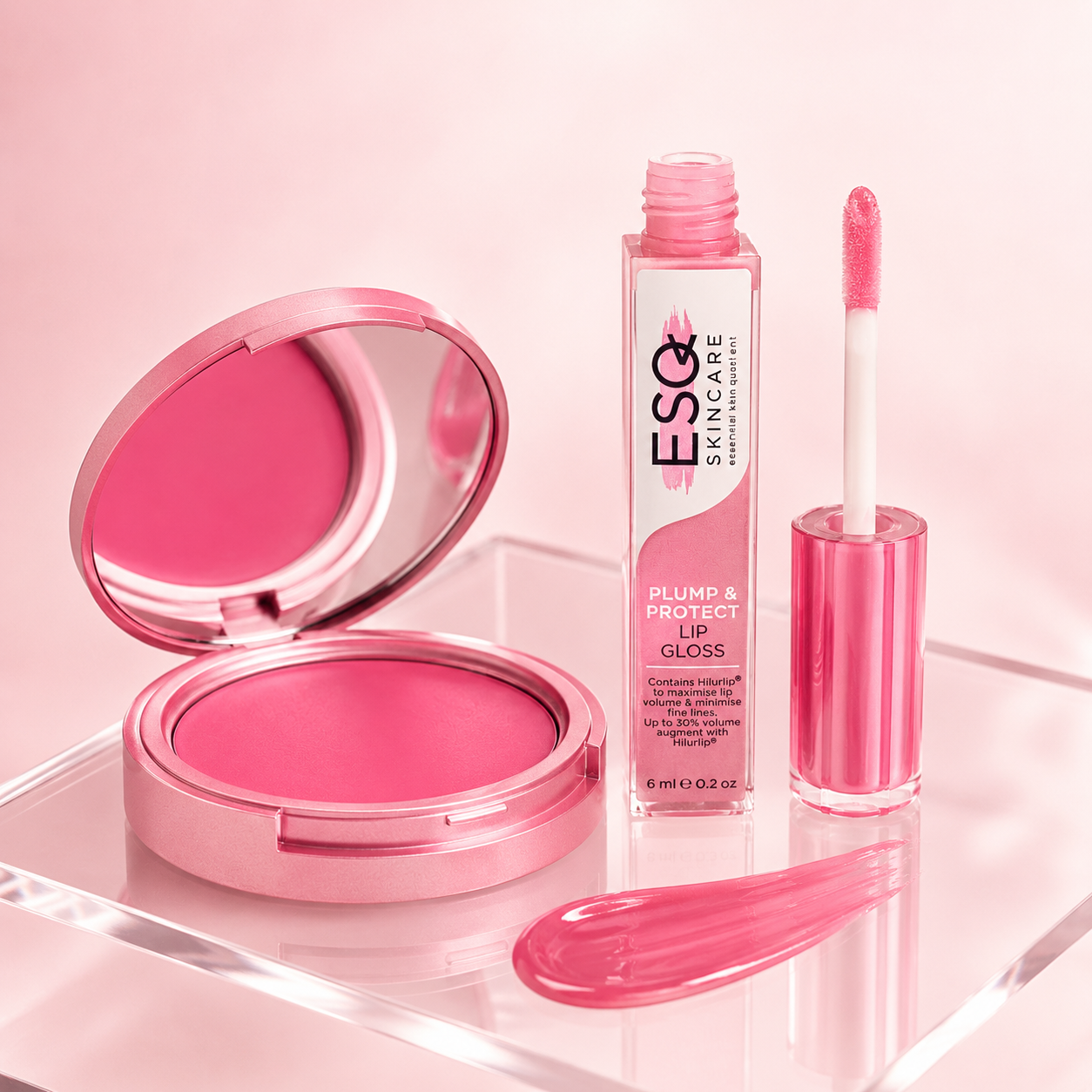 Pink makeup set on a clear acrylic tray, featuring an open pink compact mirror with bright pink powder, a bottle of ESQZ Plump & Protect Lip Gloss, and the applicator wand.