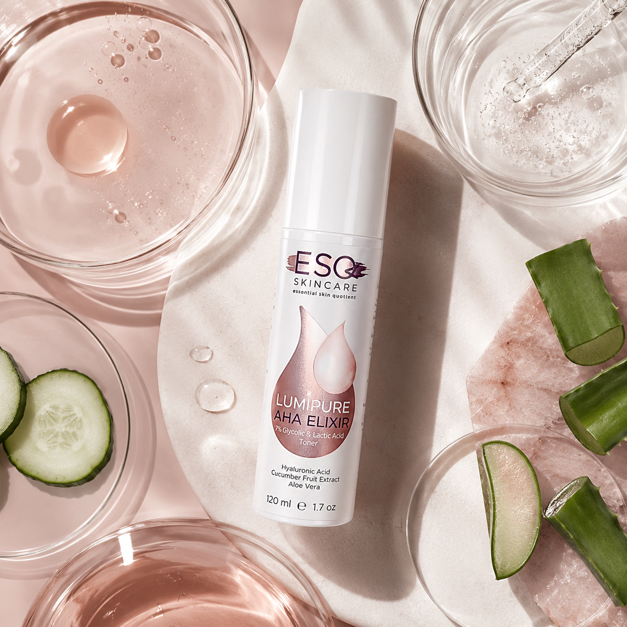 A bottle of ESO Skincare Lumipure AHA Exfoliating Treatment is styled in a flat-lay arrangement with skincare props like aloe vera slices, rose water, and a pink exfoliating mask on a light pink background.