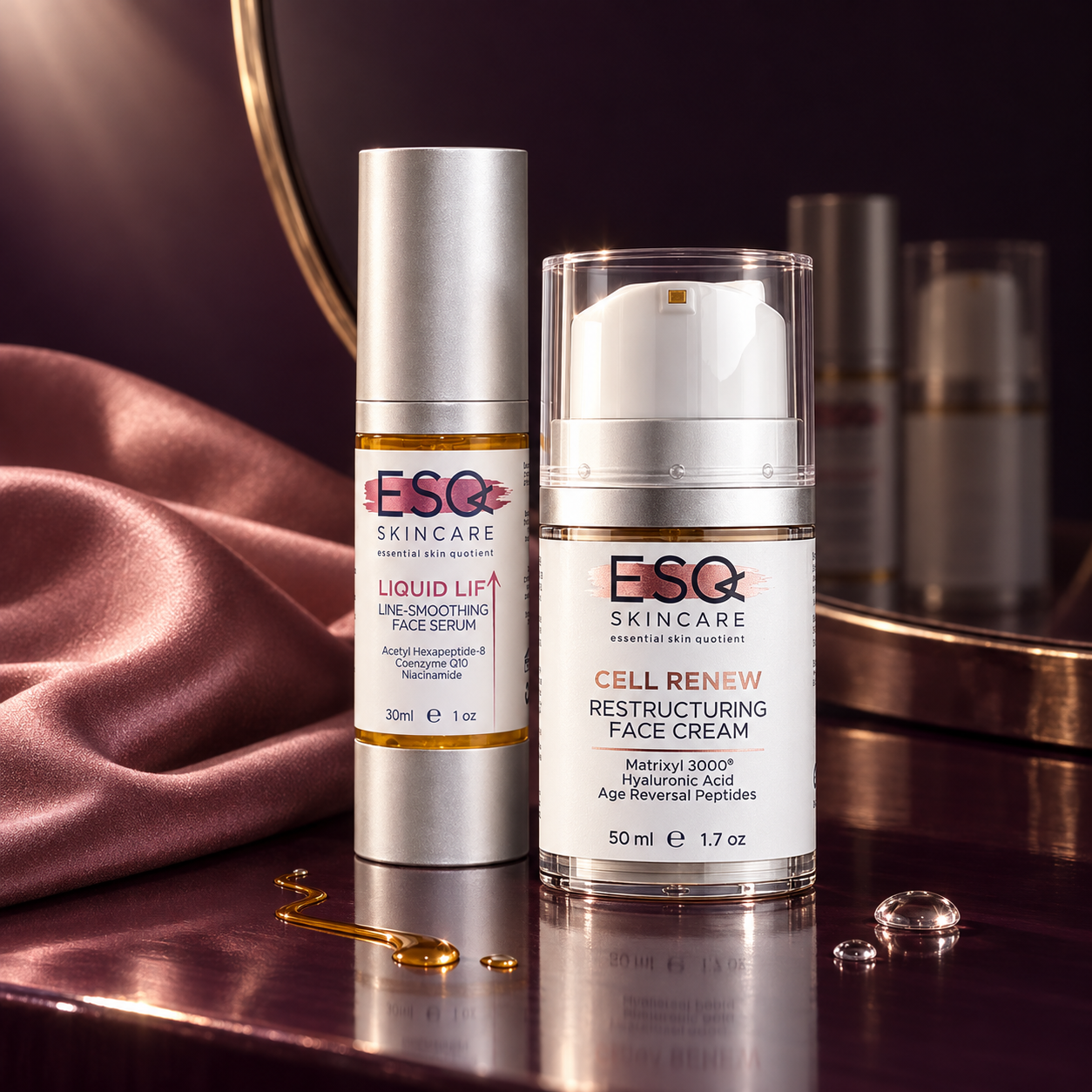 Two ESQ Skincare products on a reflective metallic surface: a silver bottle of Liquid Lift Line-Smoothing Face Serum and a clear bottle with a white pump of Cell Renew Restructuring Face Cream, styled with pink satin fabric and gold-toned props.