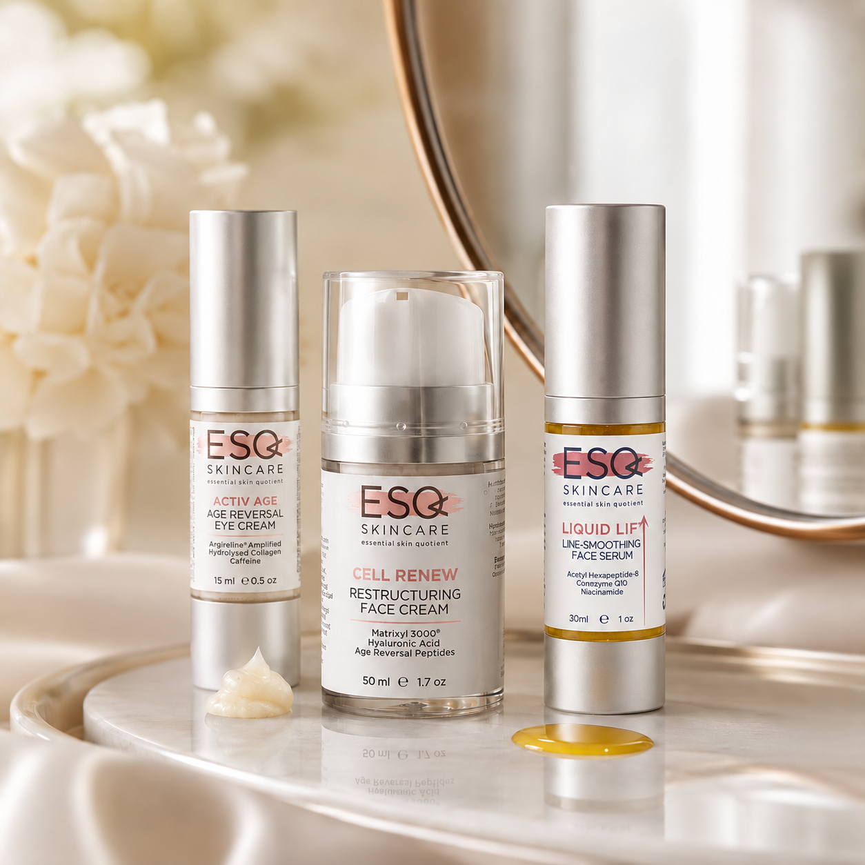 Three ESC Skincare skincare bottles arranged on a marble surface with a mirror and soft cream-colored flowers in the background. The products include an eye cream, a retinol face cream, and a liquid lifting face serum.