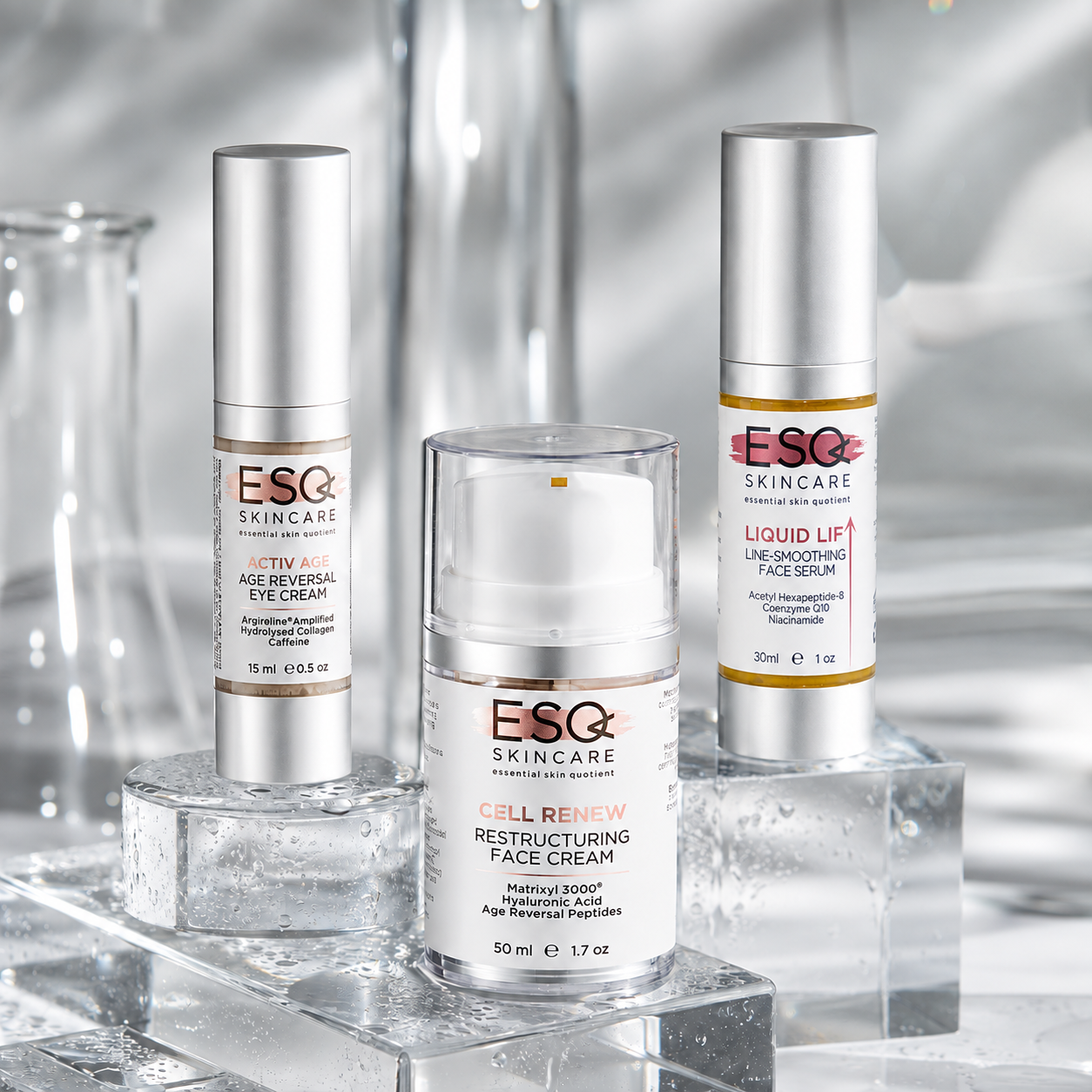 Three ESG Skincare products displayed on clear acrylic blocks: Activity Age-Brevial Eye Cream, Cell Renew Restructuring Face Cream, and Liquid Lift Line-Smoothing Face Serum, with a soft silver studio background.