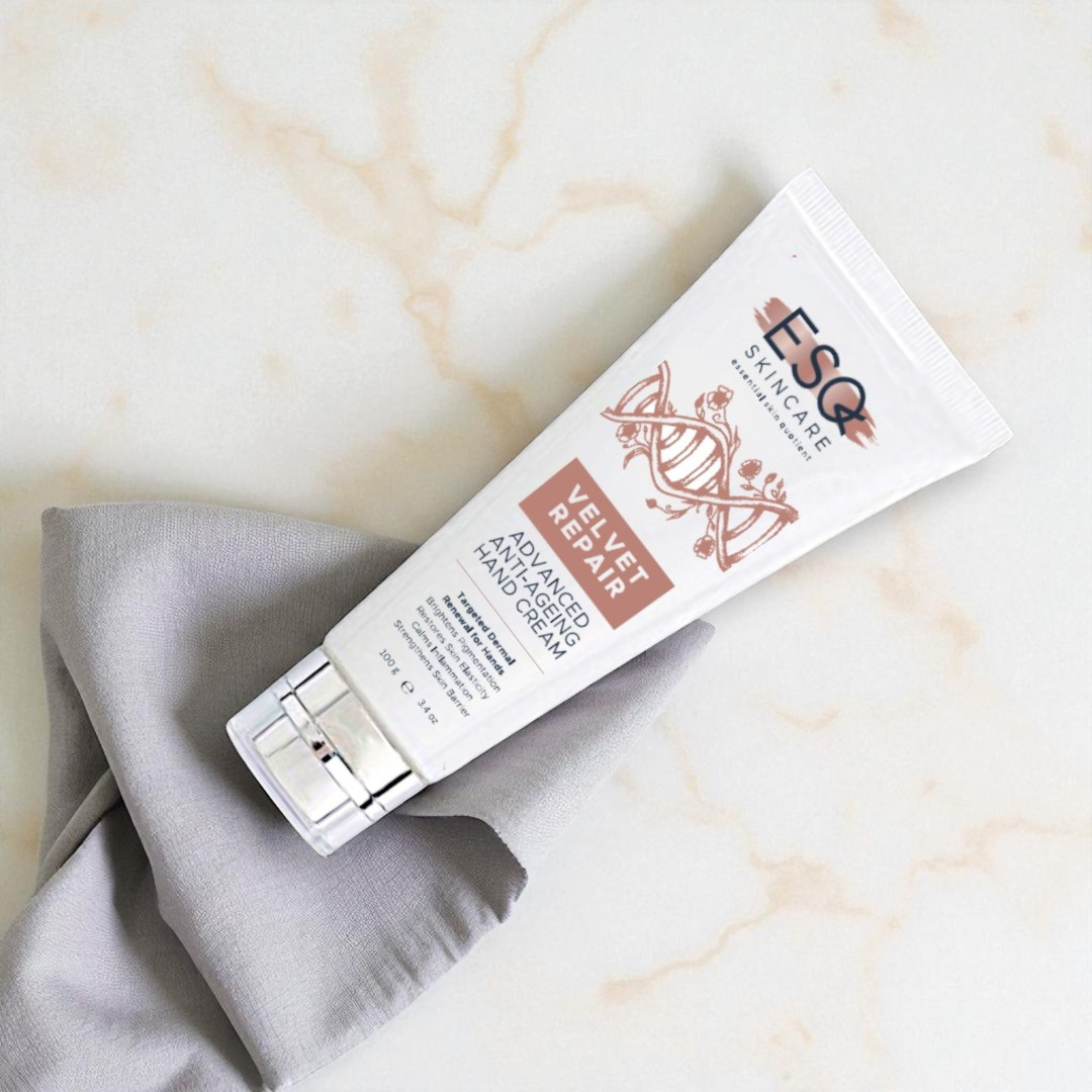Tube of E&Q skincare cream on a marble surface with a gray cloth
