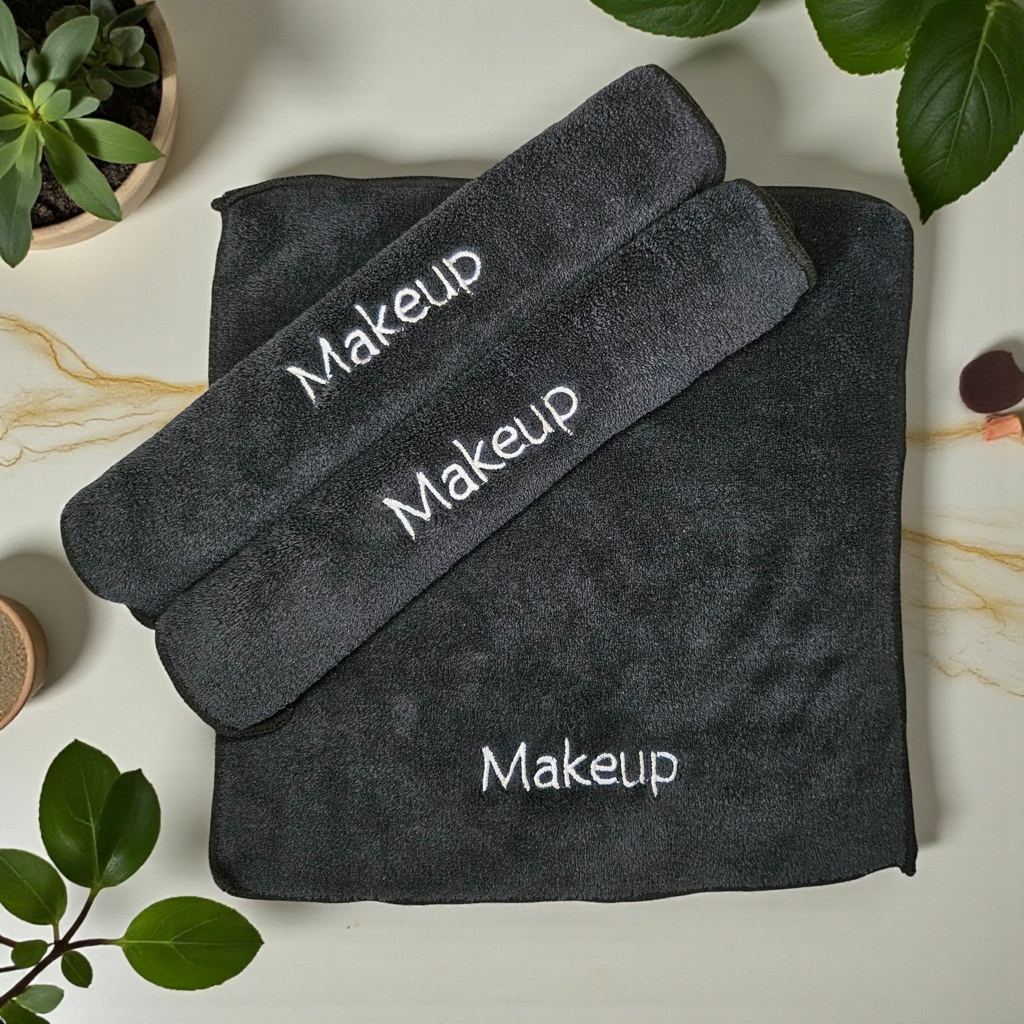 A soft, eco-friendly ESQ Skincare Clean Slate™ Microfiber Cloth in a neutral tone, neatly folded beside a skincare routine setup, highlighting its gentle, reusable, and sustainable design for effortless makeup removal. 🌿✨