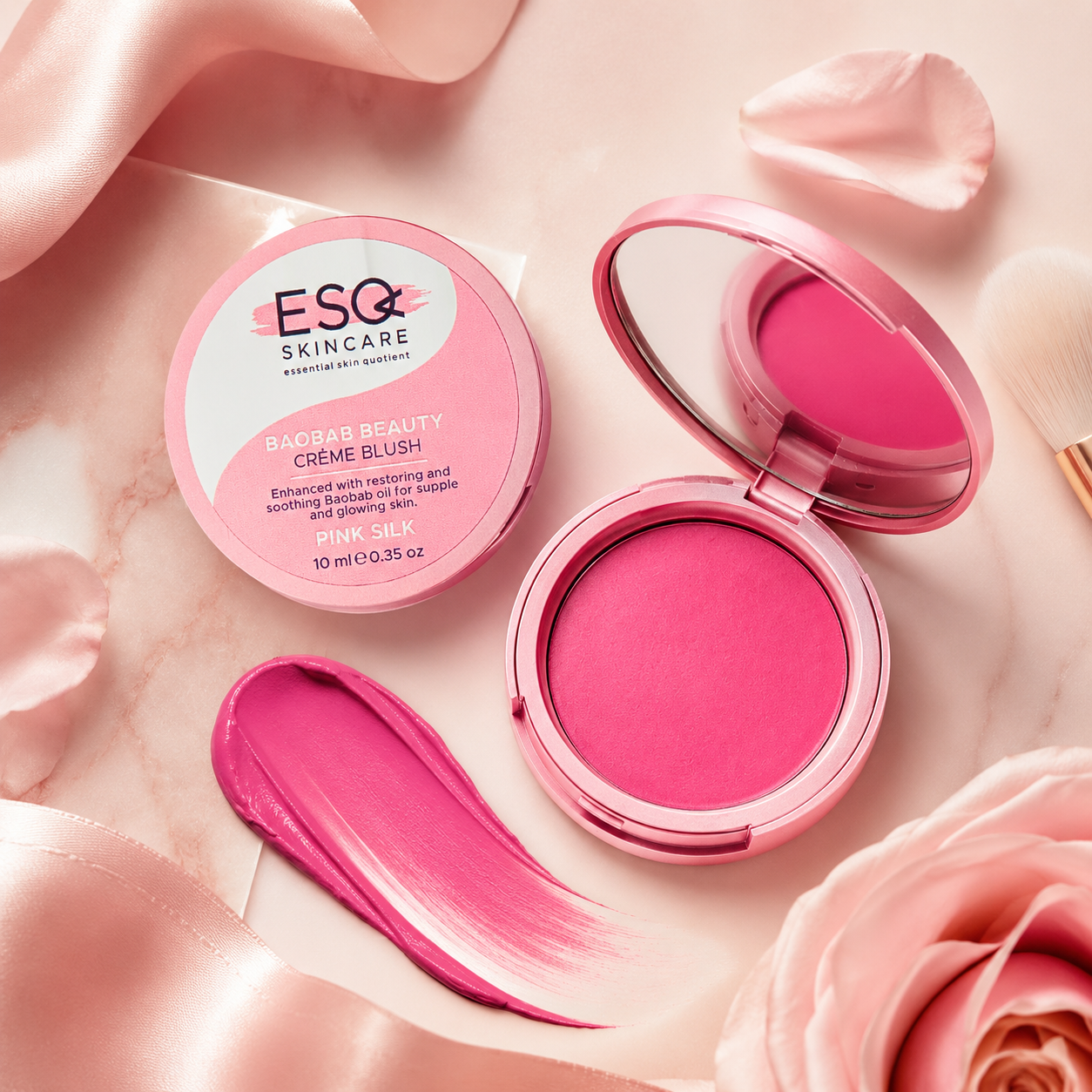 ESG Skincare Balm Beauty Creme Blush in Pink Candy, shown with the closed round compact, an open compact displaying the pink powder and mirror, a pink brush stroke of cream, and soft pink satin and rose petals on a marble surface.