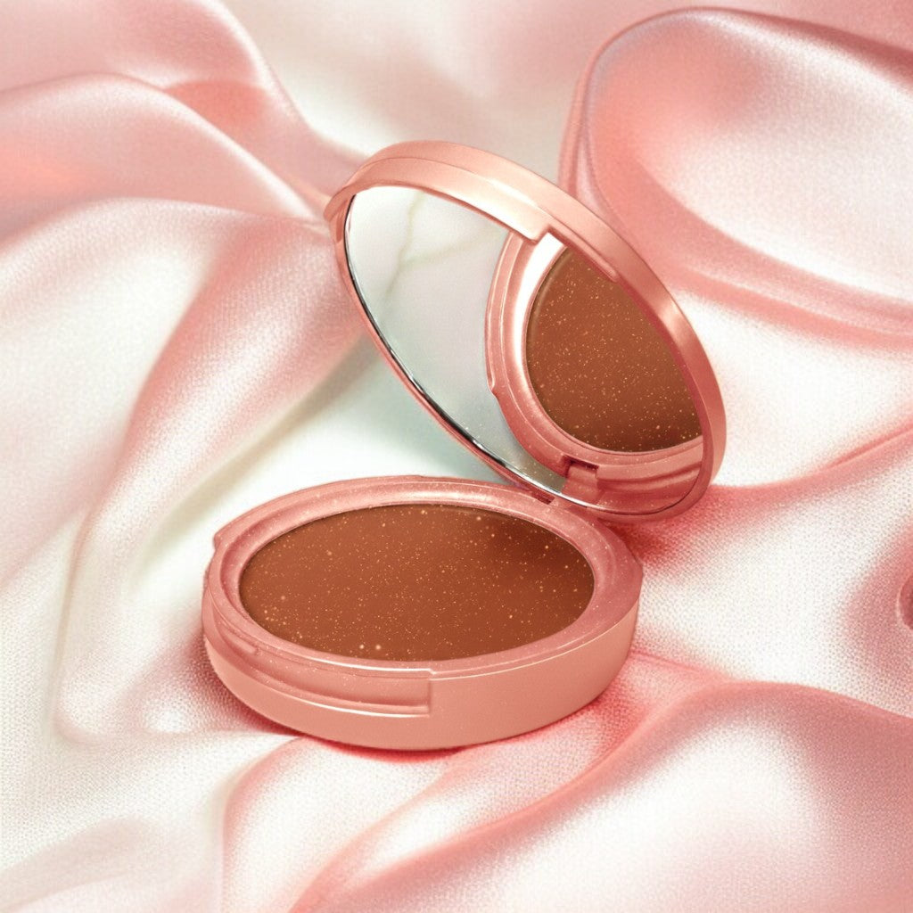 Compact powder in a rose gold case on a pink satin background