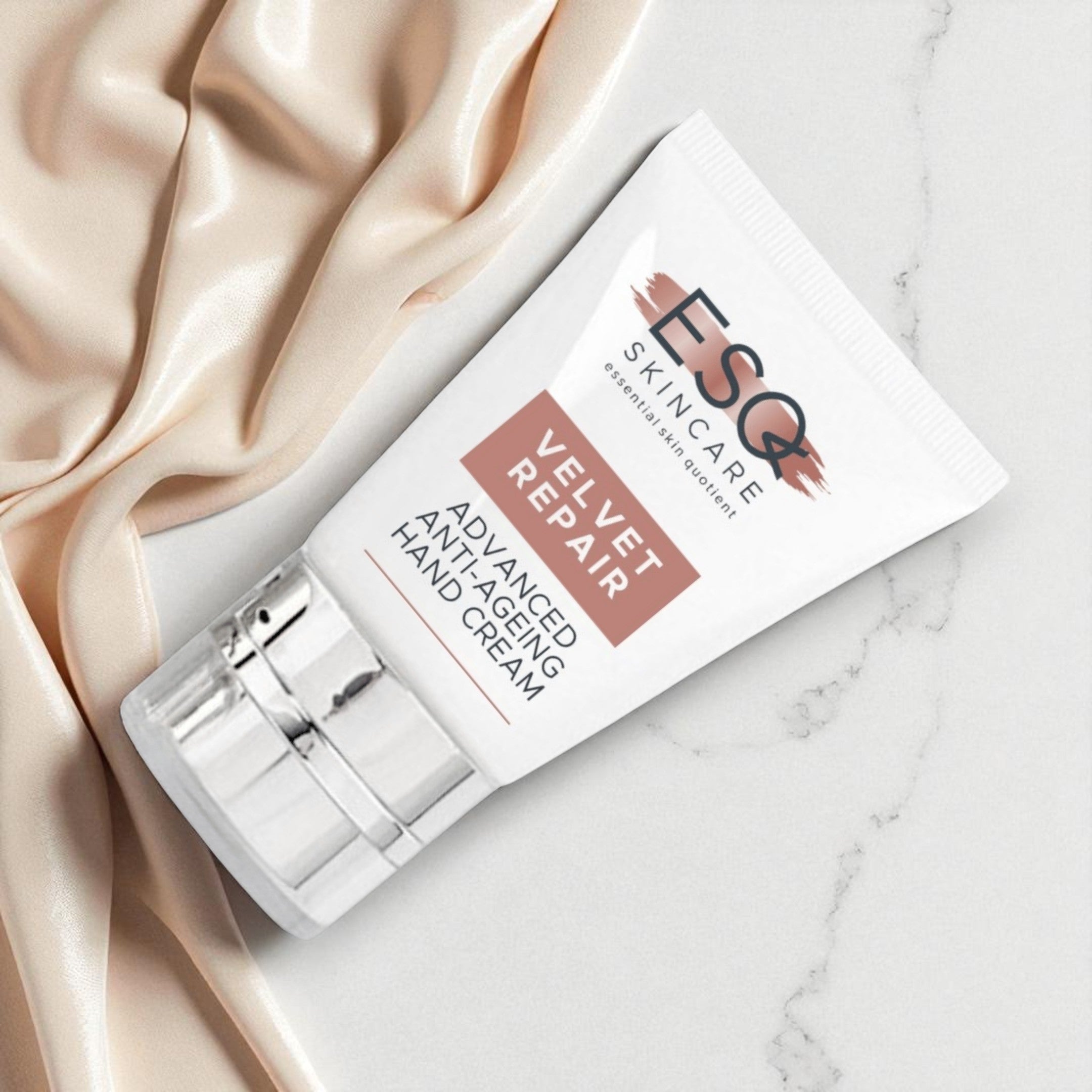 Hand cream with packaging on a marble surface with satin fabric