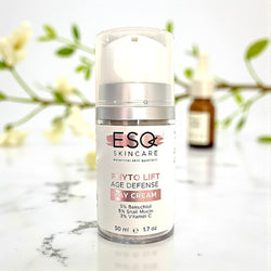 Skincare cream bottle with ESQ Skincare label on a marble surface with blurred flowers in the background