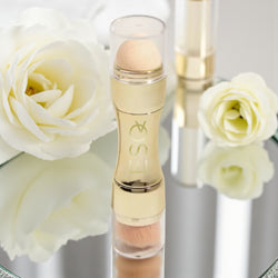 Makeup product with white roses in the background